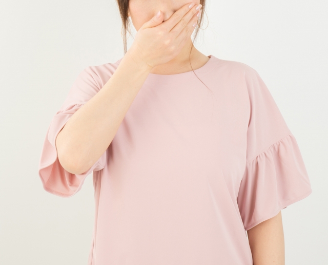 鼻をおさえる女性